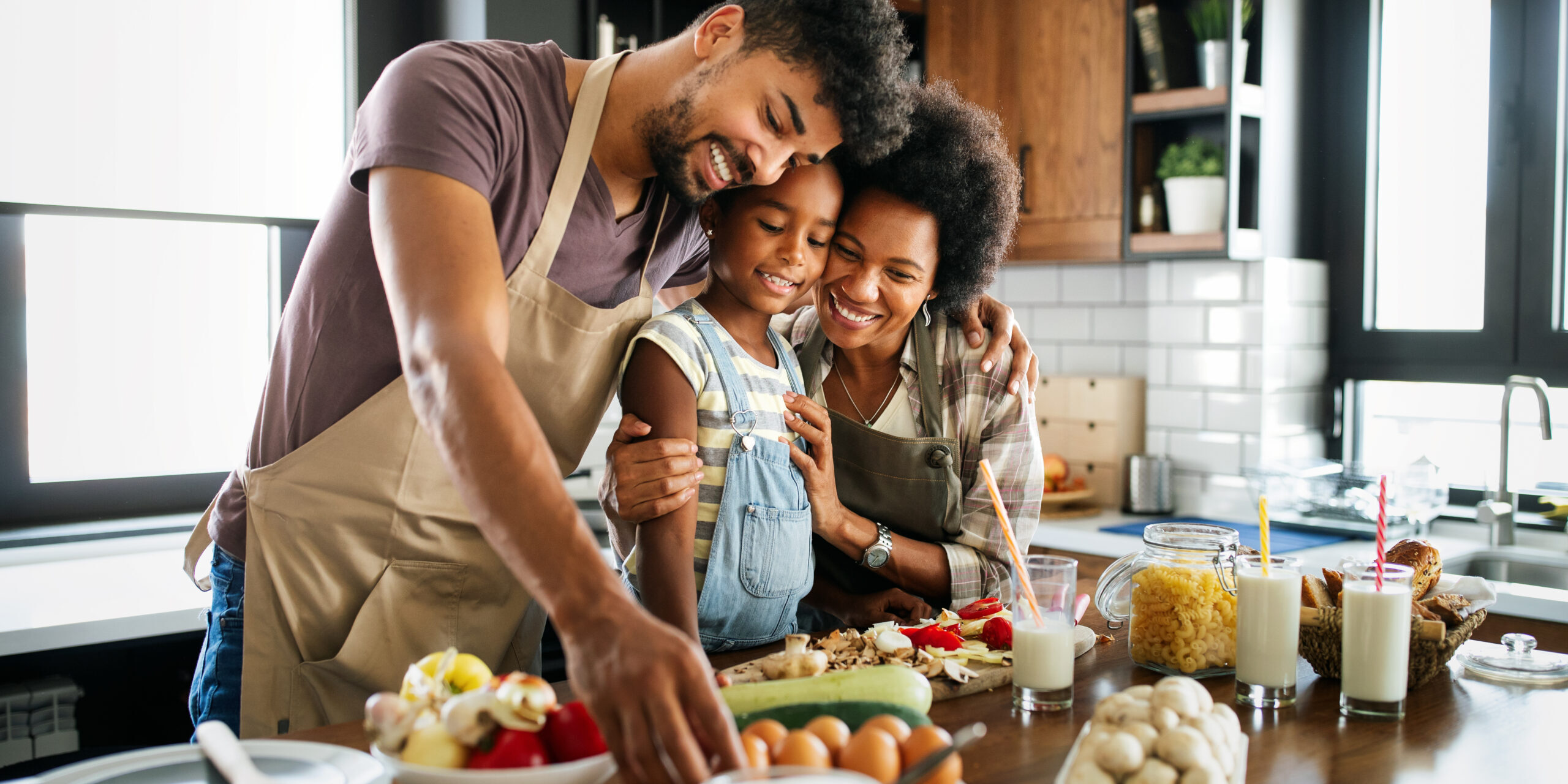 Happy african american family preparing healthy food in kitchen together